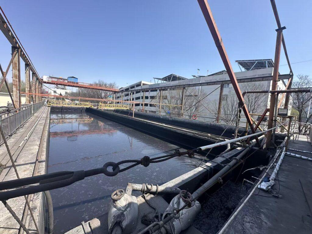 Industrial water treatment facility with open clarifier tank and pipeline infrastructure used in municipal or industrial wastewater treatment processes