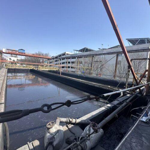 Industrial water treatment facility with open clarifier tank and pipeline infrastructure used in municipal or industrial wastewater treatment processes